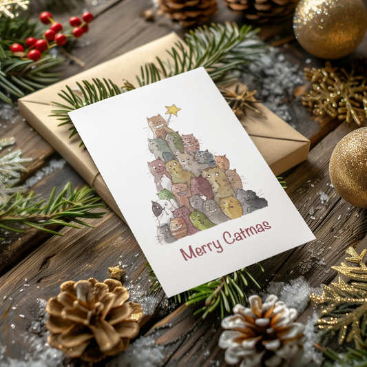 Christmas card with cat-themed tree surrounded by festive decorations on a wooden surface.